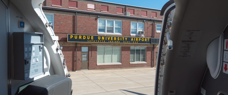 Purdue university airport sign as seen from an Envoy E175 aircraft exit door