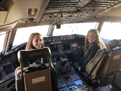 Two female OSU students pose in the flight deck of a 777