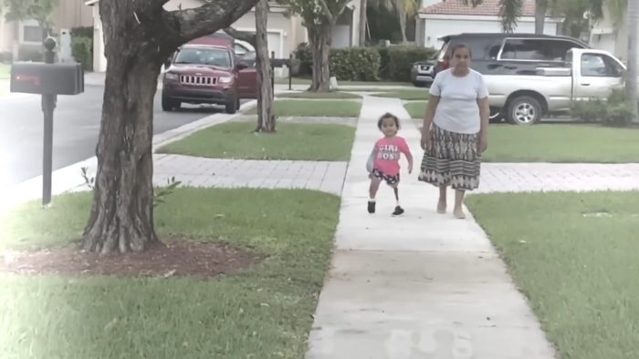 Kristen walks on a neighborhood sidewalk with her "abuelita".